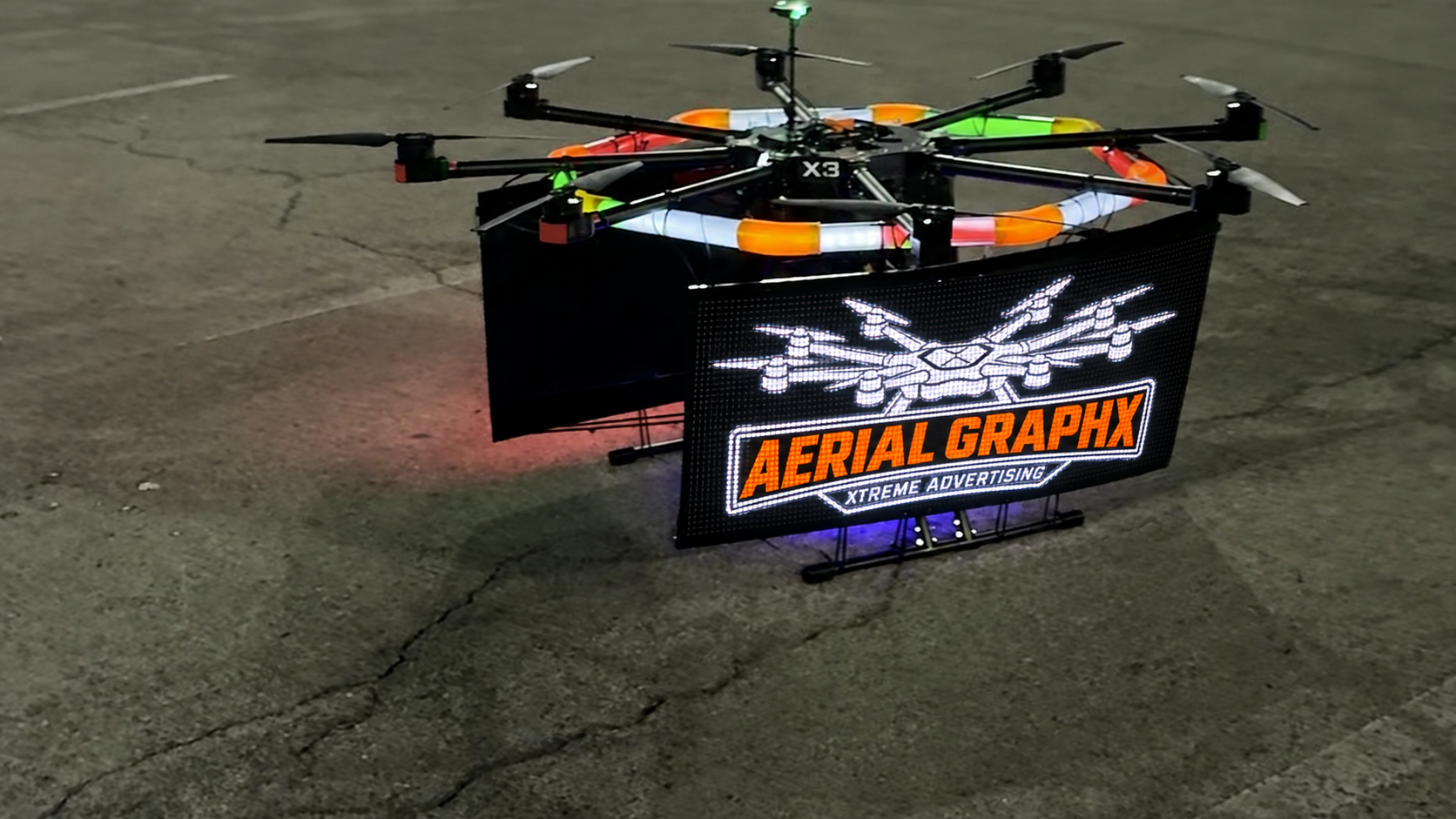 Aerial GraphX aircraft with its white and orange logo visualized on the front LED screen